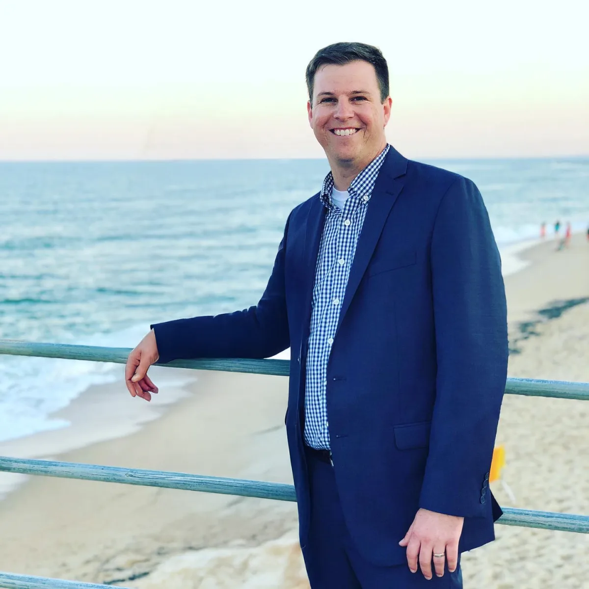 Patrick Brennan standing on a pier with the ocean behind him